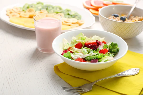 Lezzetli yulaf ezmesi ve ahşap arka plan üzerinde sebze salatası. Sağlıklı beslenme kavramı. — Stok fotoğraf