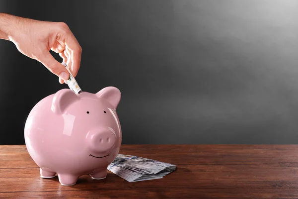 El hombre poniendo dinero en la caja de dinero — Foto de Stock