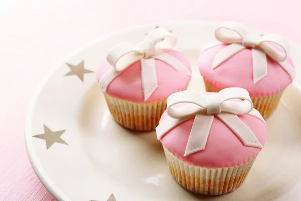 Νόστιμο cupcakes με τόξο σε ξύλινα φόντο χρώμα — Φωτογραφία Αρχείου