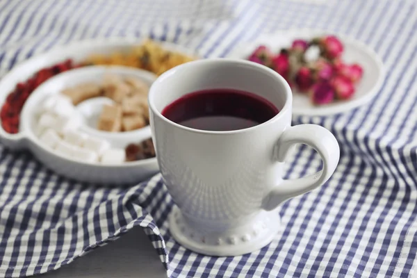 Tasse Tee mit aromatischem, trockenem Tee auf Holzgrund — Stockfoto