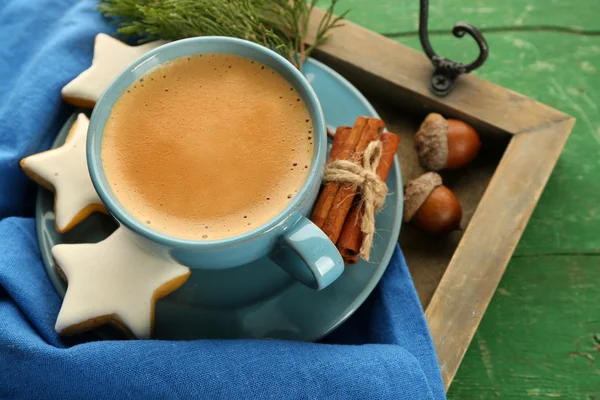 Secangkir kopi dengan bintang berbentuk biskuit di serbet di baki kayu — Stok Foto