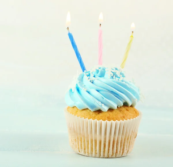 Läckra blå cupcakes dekorerade med ljus på ljus bakgrund — Stockfoto