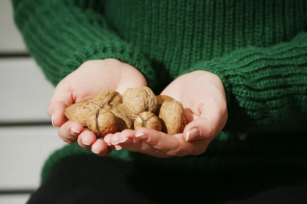 Kvinna anläggning valnötter — Stockfoto