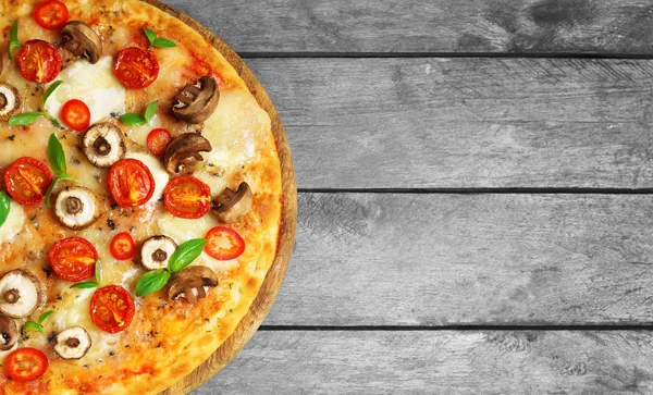 Gustosa pizza fresca decorata con funghi e pomodori su sfondo di legno, da vicino — Foto Stock