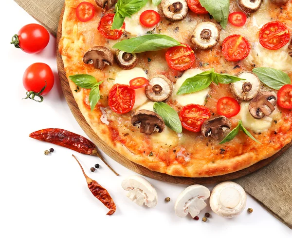 Pizza saporita e verdure fresche su tavola di legno rotonda, primo piano — Foto Stock