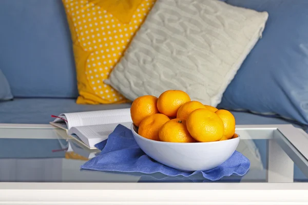 Миска зі свіжими мандаринами на столі у вітальні, крупним планом — стокове фото