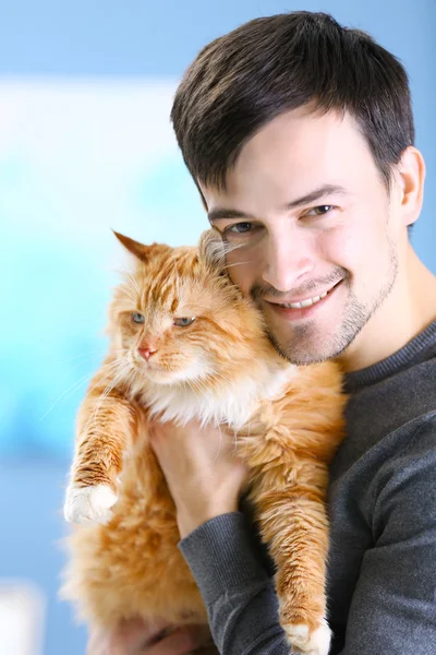 Uomo sorridente in possesso di gatto rosso — Foto Stock