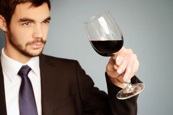 Человек смотрит на бокал красного вина — стоковое фото