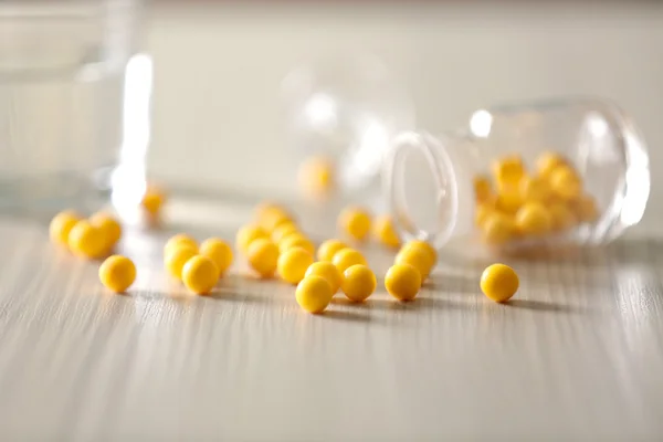 Gelbe Kapseln aus Tablettenflasche verschüttet — Stockfoto