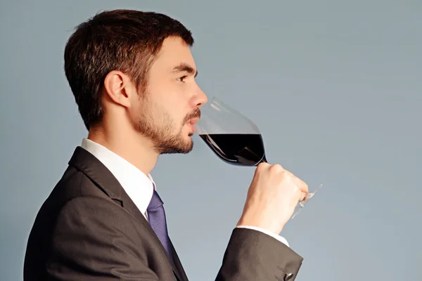 Человек в костюме с красным вином — стоковое фото