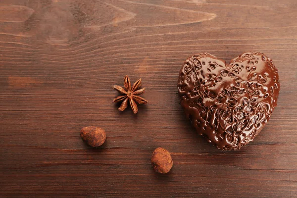 Chocolate heart on a wooden background, close up