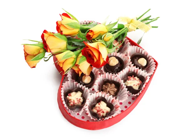 Hartvormige doos met snoepjes en bloemen, geïsoleerd op wit — Stockfoto