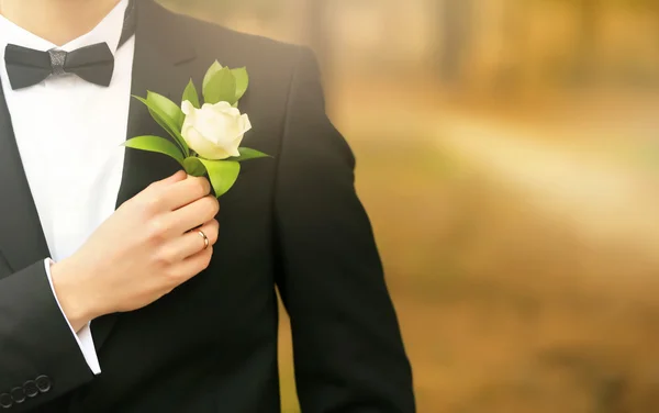 Groom dans un costume tenant boutonnière — Photo