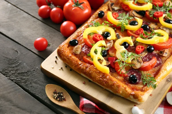 Rectangle délicieuse pizza et légumes sur la table — Photo