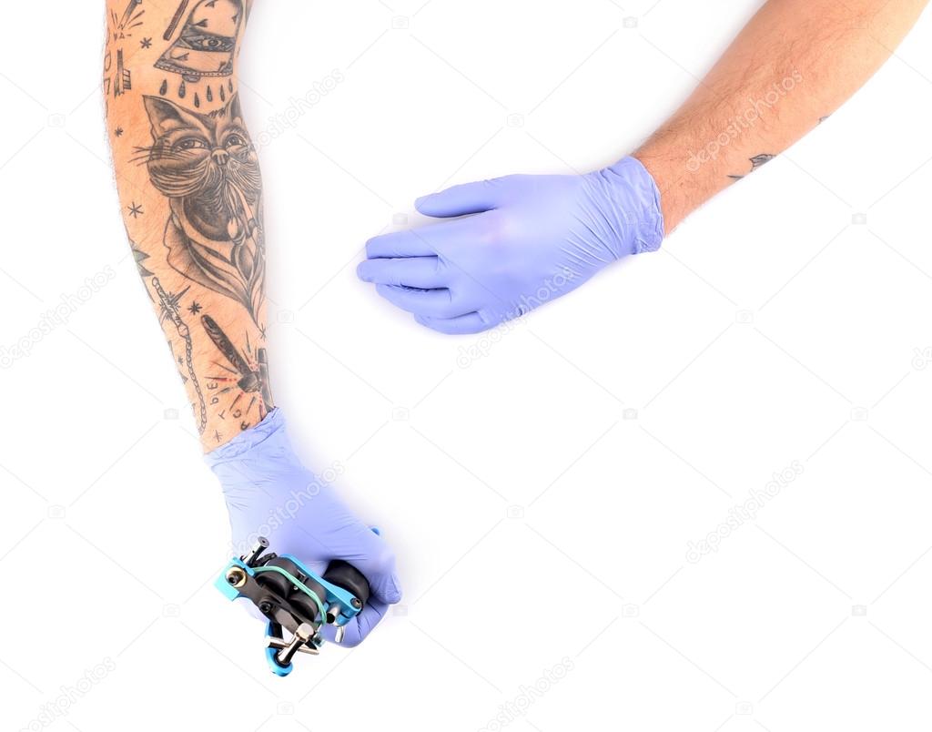 Tattooist hands in gloves with tattoo machine