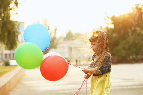 Kleines Mädchen mit Luftballons — Stockfoto