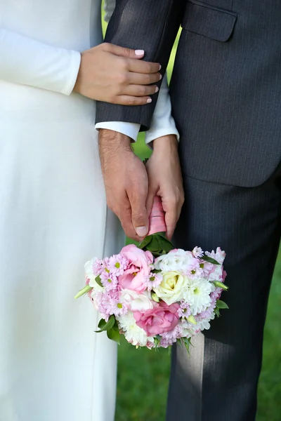 Bruden och brudgummen håller bukett — Stockfoto