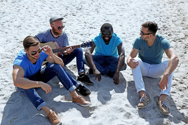Muži, sedící na písku — Stock fotografie