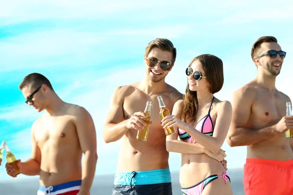 Happy vrienden drinken bier op strand — Stockfoto