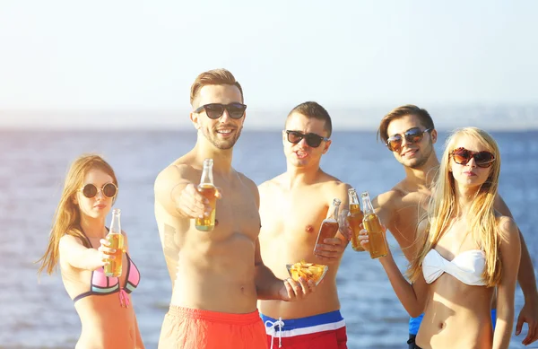 Happy vrienden drinken bier op strand — Stockfoto