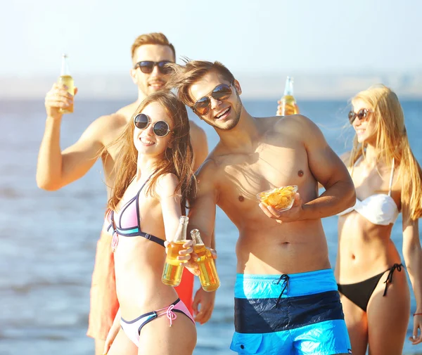 Amigos felices bebiendo cerveza en la playa —  Fotos de Stock