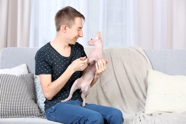 Joven hombre guapo sosteniendo un gato — Foto de Stock