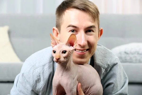 Handsome man lies with cat on floor — Stock Photo, Image