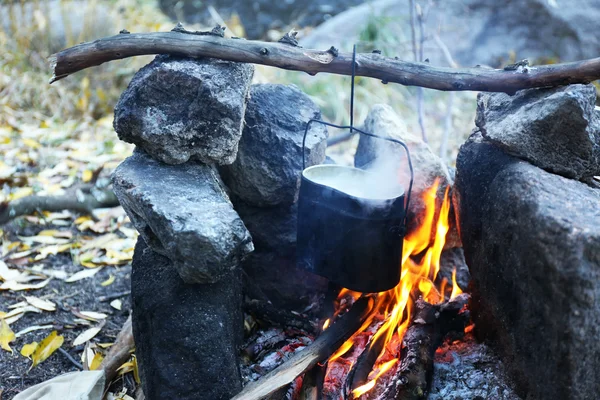 Vattenkokare hängande ovanför eld — Stockfoto