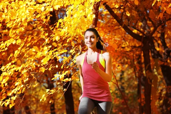 Vrouw joggen in herfst park — Stockfoto