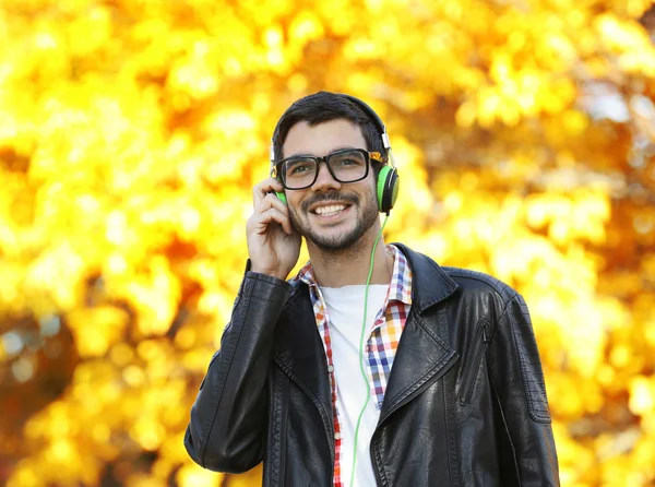 Man, luisteren naar muziek in een park — Stockfoto