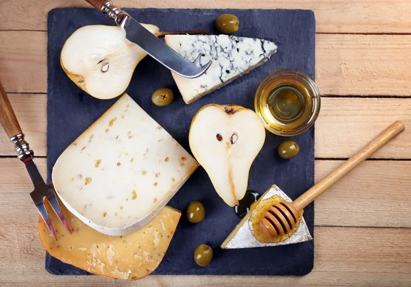 Různé druhy sýra s medem na dřevěný stůl — Stock fotografie