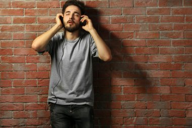 Kulaklıkla müzik dinleyen genç adam. 