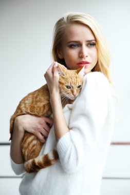 kadın kırmızı kedi elinde tutar.