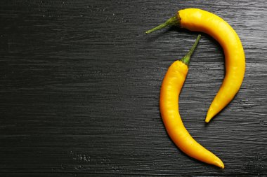 Koyu ahşap zemin üzerine sarı biber