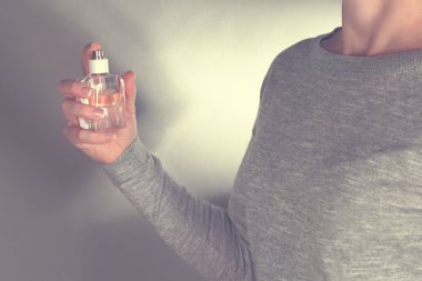 Kadın parfüm sıkıyor. 