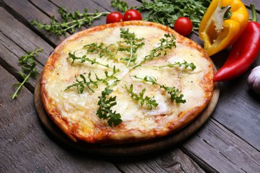 Lezzetli pizza ahşap arka plan üzerinde sebze ve otlar ile dekore edilmiş, yakın çekim