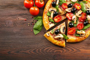 Sebze ile lezzetli lezzetli pizza ahşap masanın üzerine dilimlenmiş