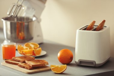 Ekmek kızartma makinesi mikser ve bir ışık mutfak masasında portakal ile