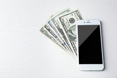 Doları banknot masa lambası üzerinde akıllı telefon. Internet kazanç kavramı