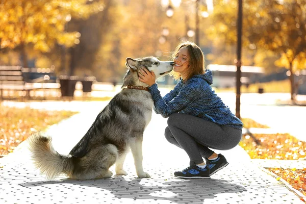 Kvinna promenader med hund i parken — Stockfoto