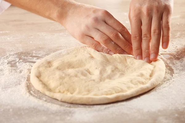 Hands preparing dough basis for pizza — Stock Photo, Image