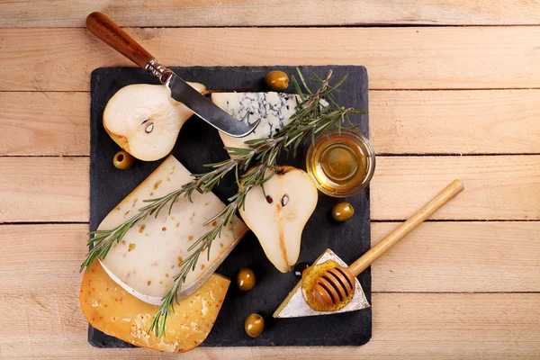 Diferentes tipos de queijo com mel na mesa de madeira — Fotografia de Stock