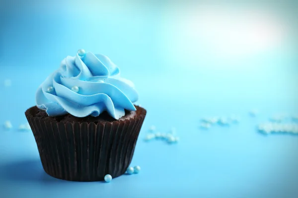 Chocolate cupcake on blue background — Stock Photo, Image