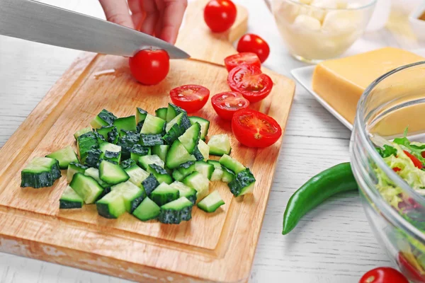 Las manos femeninas cortan hortalizas para la ensalada, a la cocina —  Fotos de Stock