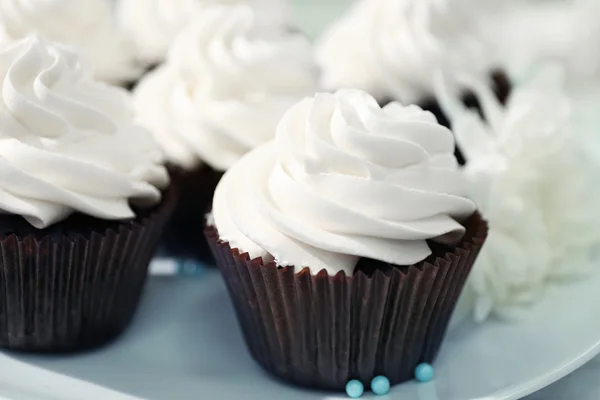 Cupcakes au chocolat et fleurs sur une table — Photo