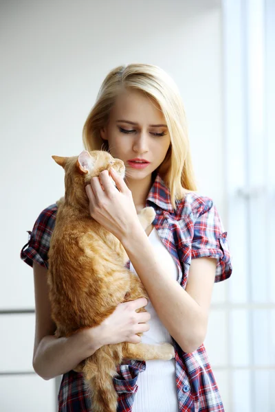 Genç kadın kırmızı kedi ile poz — Stok fotoğraf