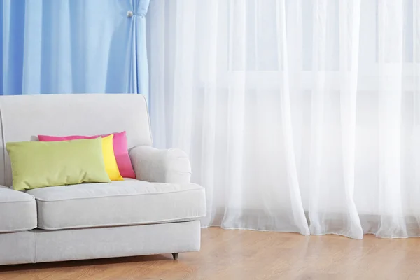 Sofá no quarto com cortinas — Fotografia de Stock