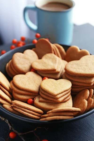Sušenky a šálek kakaa na stůl ve tvaru srdce — Stock fotografie