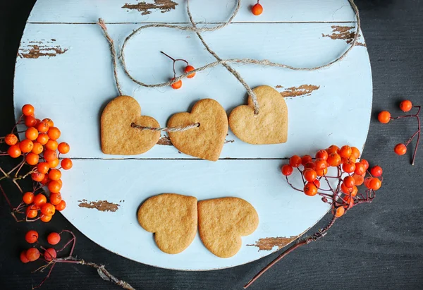 Biscotti a forma di cuore con bacche di frassino su un tappetino rotondo, vista dall'alto — Foto Stock