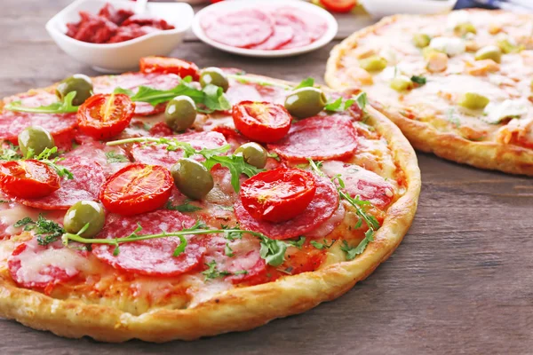 Heerlijke smakelijke pizza's met ingrediënten op tafel, close-up — Stockfoto